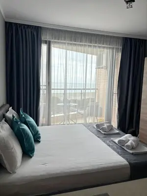 a bedroom with a large bed with a large window at Studio Sea Pearl in Pomorie