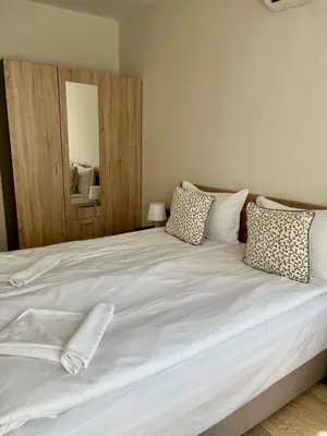 a bedroom with a large white bed with pillows at Apartments Flora 1 in Burgas City
