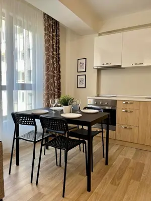 a kitchen with a table and chairs in a room at Apartments Flora 1 in Burgas City
