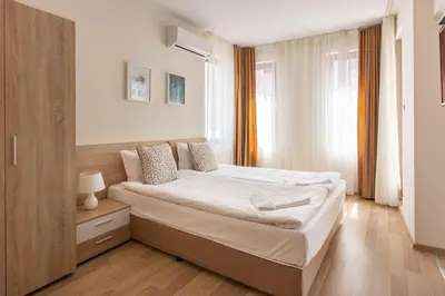 a bedroom with a large bed in a room at Apartments Flora 1 in Burgas City