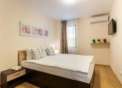 a bedroom with a bed and a television in it at Apartments Flora 1 in Burgas City