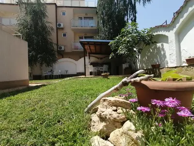 a garden with flowers and a building in the background at Siana House in Ravda