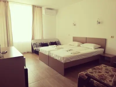 a hotel room with two beds and a window at Siana House in Ravda