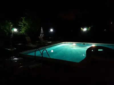 an empty swimming pool at night with lights at Abelia Residence Apartment Regina in Sunny Beach