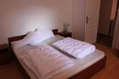 a bed with two white sheets and pillows on it at Abelia Residence Apartment Regina in Sunny Beach