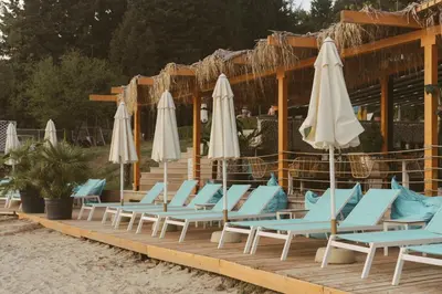 a row of lounge chairs and umbrellas on a beach at Rich Collective in Nesebar