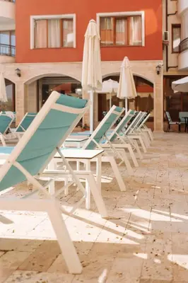 a row of lounge chairs and umbrellas on a patio at Rich Collective in Nesebar