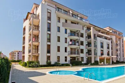 a large building with a swimming pool in front of it at Alex Deluxe Apartments in Sunny Beach