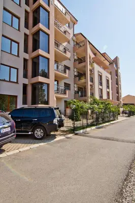 a van parked in a parking lot in front of a building at Alex Deluxe Apartments in Sunny Beach