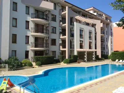 a hotel with a swimming pool in front of a building at Alex Deluxe Apartments in Sunny Beach