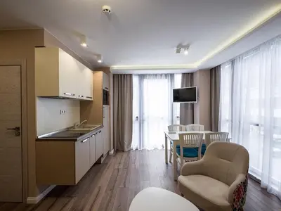 a kitchen and living room with a table and chairs at Caro Apartments & Rooms in Varna City