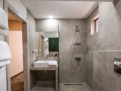 a bathroom with a sink and a shower at Caro Apartments & Rooms in Varna City