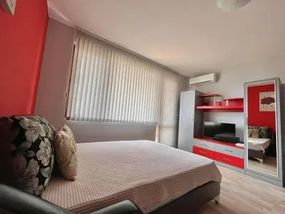 a bedroom with a bed and a dresser and a mirror at Sirena Holidays in Ravda