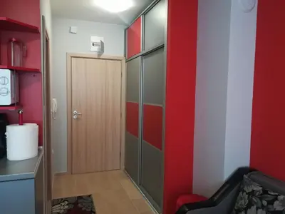 a room with a door and a red wall at Sirena Holidays in Ravda