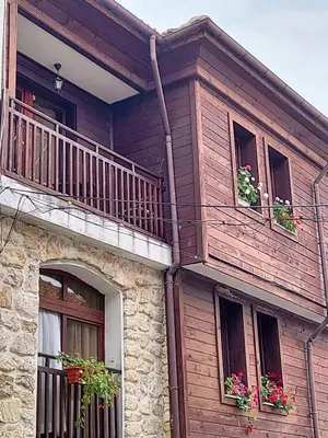 a house with two balconies and flowers in the windows at Guest Rooms Melsambria in Nesebar