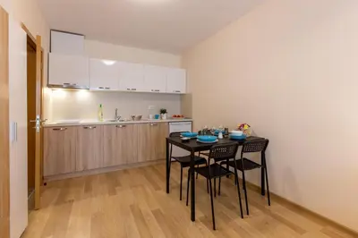 a kitchen with a table and chairs in a room at Apartments Flora in Burgas City