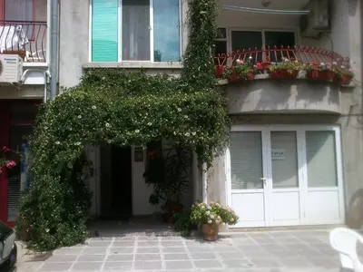 a building with a balcony with flowers on it at Rooms Via Maris in Sozopol