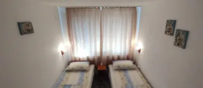 two beds in a small room with a window at Rooms Via Maris in Sozopol