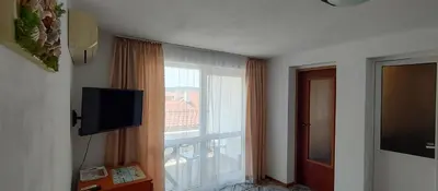 a room with a large window and a television at Rooms Via Maris in Sozopol