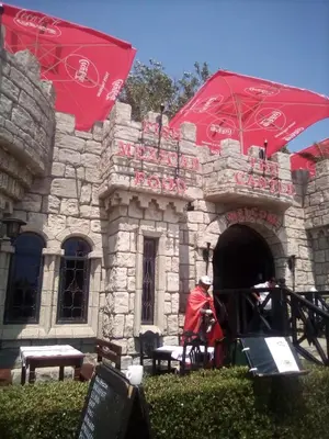 a stone building with red umbrellas in front of it at Santa Sofia Studio in Sunny Beach