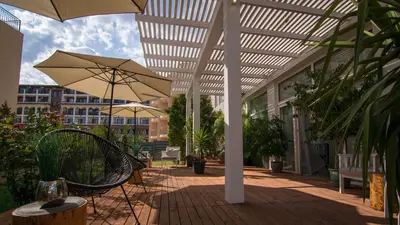 a patio with an umbrella and a bench and a table at The Mint Villa - Saint Vlas in Sveti Vlas