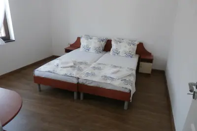 a small bed with blue and white sheets and pillows at Aleksandrovo Apartments in Aleksandrovo