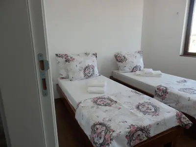 two twin beds in a room with a window at Aleksandrovo Apartments in Aleksandrovo