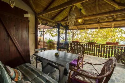 a porch with a wooden table and chairs on a patio at Art Provence House in Lozenets