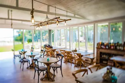a dining room with tables and chairs and windows at St Anastasia Hotel in Burgas City