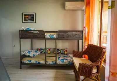 a bedroom with two bunk beds and a chair at Studios Grace - Port Tsarevo in Tsarevo