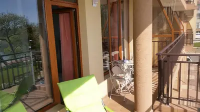 a balcony with a chair and a table on a balcony at Studios Grace - Port Tsarevo in Tsarevo