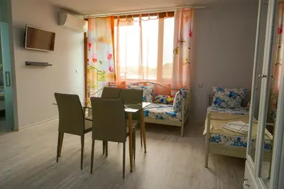 a dining room with a table and chairs and a couch at Studios Grace - Port Tsarevo in Tsarevo