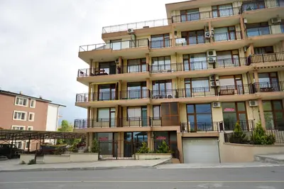an apartment building with balconies and a street at Studios Grace - Port Tsarevo in Tsarevo