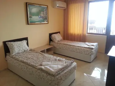 a room with two beds and a couch and a window at Joro Guest House in Sveti Vlas