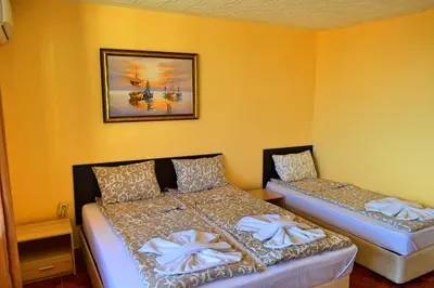 a bedroom with two beds and a picture on the wall at Joro Guest House in Sveti Vlas