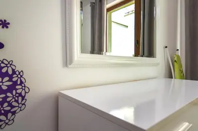 a bathroom with a white counter and a mirror at The Cozy Apartment in Varna City