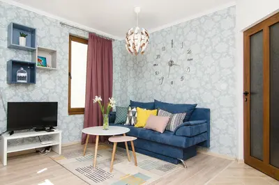 a living room with a blue couch and a table at The Cozy Apartment in Varna City