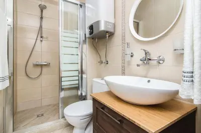 a bathroom with a sink and a toilet and a mirror at The Cozy Apartment in Varna City