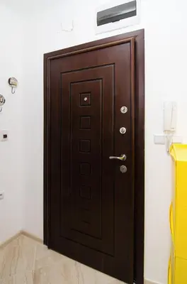 a wooden door in the corner of a room at The Cozy Apartment in Varna City