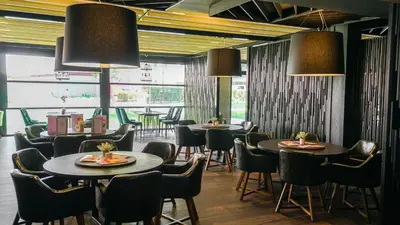 a dining room with tables and chairs and large windows at DIT Evrika Beach Club Hotel - All Inclusive in Sunny Beach