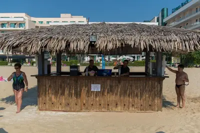 a bar on the beach with a straw hut at DIT Evrika Beach Club Hotel - All Inclusive in Sunny Beach