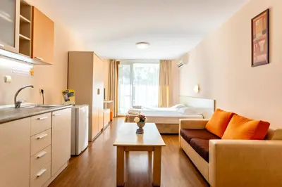 a kitchen and living room with a couch and a bed at Aparthotel Hotel Prestige City II in Primorsko