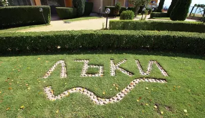 a sign written in the grass in a yard at Apartments Lucky Complex Ravda in Ravda