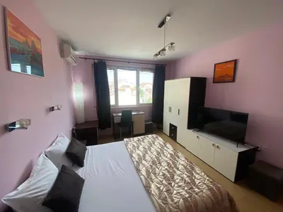 a bedroom with a bed and a television in it at Holidays apartment Bourgas in Burgas City