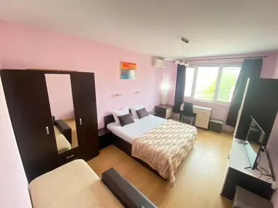 a small bedroom with a bed and a television at Holidays apartment Bourgas in Burgas City