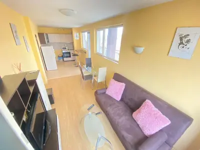 a living room with a brown couch and pink pillows at Holidays apartment Bourgas in Burgas City