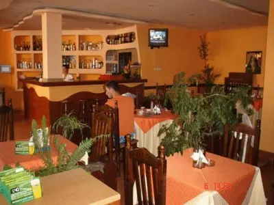 a man sitting at a table in a restaurant at Family Hotel Hit in Kiten