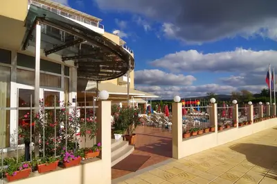 a building with potted plants and flowers on it at Hotel Plamena Palace in Primorsko