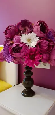 a vase filled with purple and white flowers on a table at Florata apartment in Burgas City