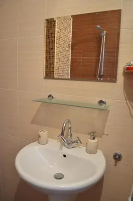 a bathroom sink with two cups on it at ART Apartments - Pomorie in Pomorie